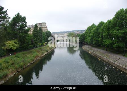 The River Avon in Bath, with Pulteney Weir, Pulteney Bridge,  and the former Empire Hotel (now converted into apartments) in the distance Stock Photo