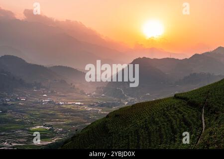 Mountain range and rice terraced fields in valley at sunset. Sa Pa in Lao Cai province, Vietnam. Stock Photo