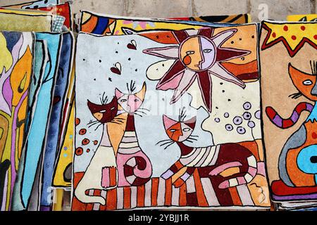 Khiva, Uzbekistan - Sept 15, 2024: Handmade silk embroidery pillows with cats motive for sale on street market in Khiva Stock Photo