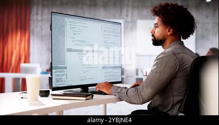African American Coder Using Computer At Desk. Web Developer Stock Photo
