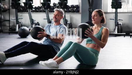 Couple Doing Abdominal Workout In Gym. Fit Athletes Stock Photo