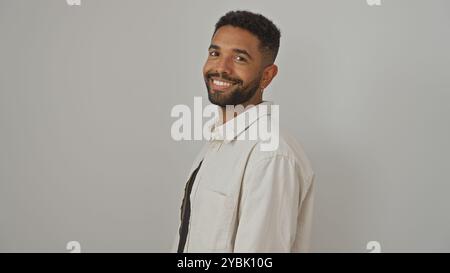 Smiling young adult black man with beard in casual shirt standing against a white background Stock Photo