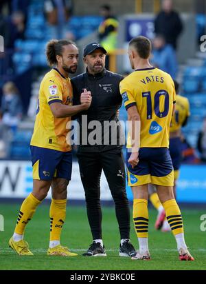 Derby County manager Paul Warne (centre) with Derby County's Marcus Harness (left) and Jerry Yates (right) during the Sky Bet Championship match at The Den, London. Picture date: Saturday October 19, 2024. Stock Photo