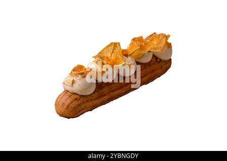 Sweet dessert eclairs or profiteroles with chocolate filling and covered with cream and dried oranges on a white background Stock Photo
