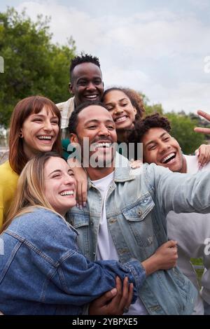 Cheerful group of friends taking smiling selfie. Group of young people having fun together outdoors Stock Photo