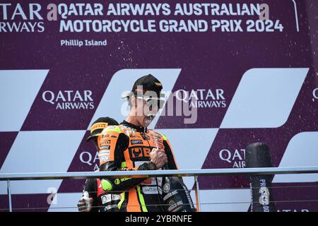 MELBOURNE, AUSTRALIA. 20th Oct 2024. Pictured: Fermin Aldeguer, #54 of Spain, riding for SpeedUp Racing celebrates by spraying champagne from the champagne bottle into his mouth after winning the Australian Moto2 Race on the Podium at the Qatar Airways Australian Motorcycle Grand Prix 2024 held at the Phillip Island Circuit. Credit: Karl Phillipson/Alamy Live News Stock Photo