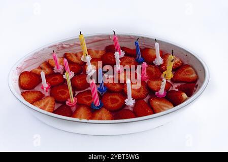 Homemade strawberry cake with birthday candles isolated on white background Stock Photo