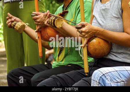 Musicians playing Afro Brazilian percussion musical instruments called berimbau during a capoeira performance in the streets of Brazil Stock Photo