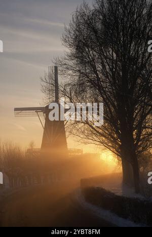 Wintery view at mill de Hoop near Oud-Alblas across the frozen river Graafstroom in the Dutch region Alblasserwaard Stock Photo