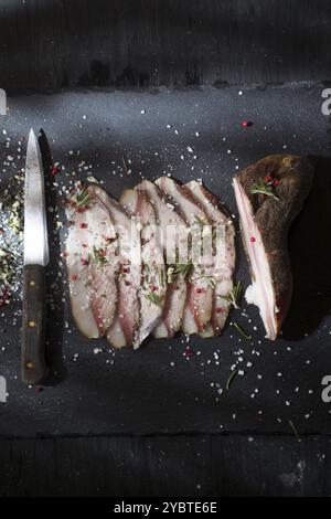 Presentation of salted pork bacon on stone slate Stock Photo