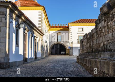 Evora, Portugal, June 29, 2022: Pousada hotel convent in the old town with buildings painted in white and yellow and ceramic tiled roofs near Temple o Stock Photo