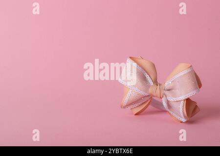 A beautiful bow made of turnip ribbon on a light pink background. copy space Stock Photo