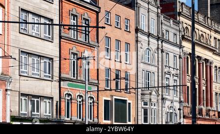 Facades of various buildings in Dublin, showcasing a contrast of red brick and stone architecture. The image highlights the urban character of the cit Stock Photo