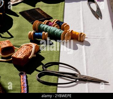 shot of ancient medieval sewing textile tools on a work table with bobbins and needles Stock Photo