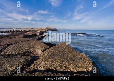 The view from the end of Filey Brigg looking back towards the land and the town of Filey. In the distance Scarborough can just be seen. Stock Photo