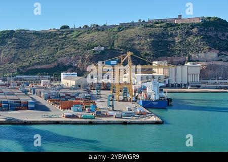 Barcelona. Espain -October 20,2024: View of the Barcelona port with a cargo ship docked and cranes unloading containers. Represents port activity and Stock Photo