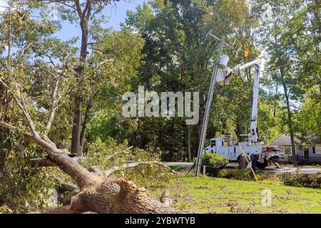 Using utility tower truck, emergency service linemen are diligently repairing power electrical lines damaged by hurricanes Stock Photo