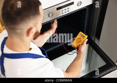 Repairman testing oven element with multimeter, above view Stock Photo