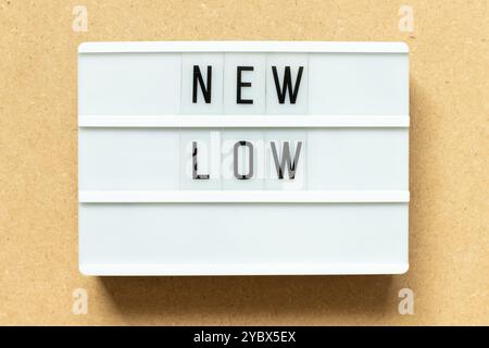 Lightbox with word new low on wood background Stock Photo