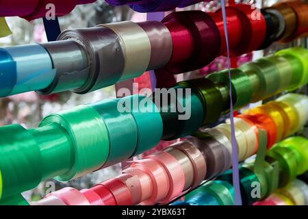 Multi-colored ribbons on a store shelf. Sewing and handicrafts Stock Photo
