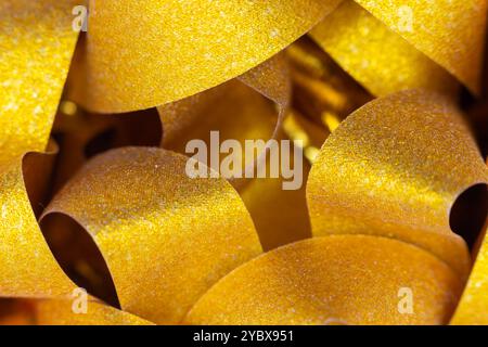 This image showcases a close-up of several curved, golden-yellow surfaces with a glittery texture. Stock Photo