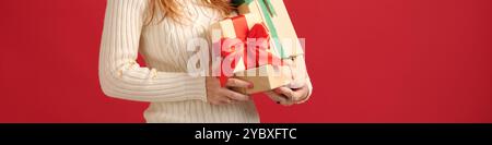 Woman Holding Gift Boxes Against Red Background Stock Photo