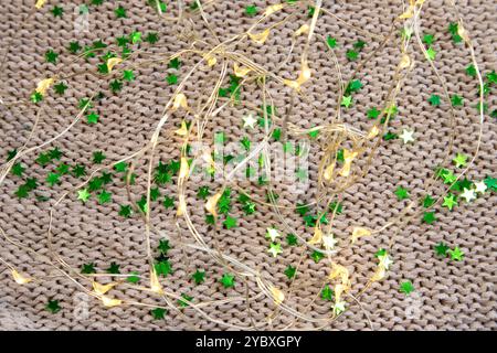 Bright green sequins tube scattered on grey knitted background close up top view Stock Photo