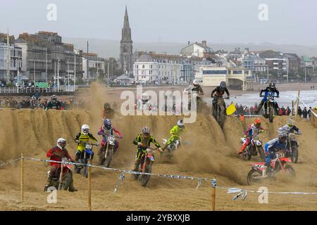 Weymouth, Dorset, UK.  20th October 2024.  Over three hundred riders watched by thousands of spectators take part in the 40th Weymouth Beach Motocross race over a makeshift course carved out of the resort's golden sand by diggers. The annual free event is run by the Purbeck Motocross Club.  Picture Credit: Graham Hunt/Alamy Live News Stock Photo