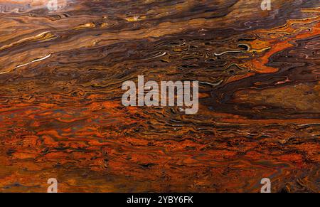 Natural granite stone texture featuring swirling patterns in warm, earthy colors, evoking a Mars-like terrain. Stock Photo