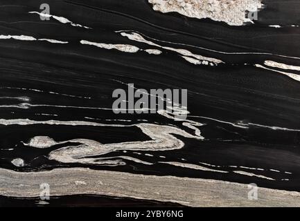Black granite slab with bold white veining, providing a textured surface for design projects. Stock Photo