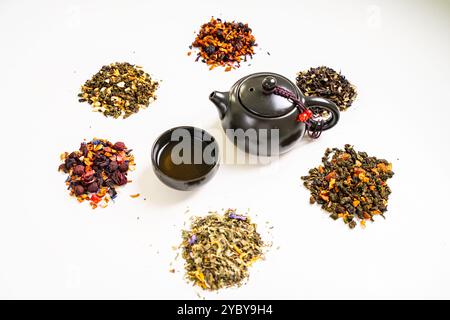 Assorted different types of tea and a teapot with cups on a white table. High quality photo Stock Photo