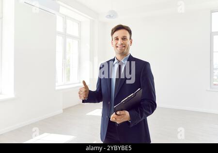 Businessman with folder showing thumb up in empty apartment, close-up Stock Photo