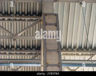 Close-up of concrete column with metal reinforcements supporting industrial building structure. Stock Photo