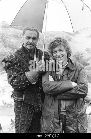 SEAN CONNERY relaxes on the set with RUSSELL MULCAHY on location in Scotland for HIGHLANDER 1986 Director RUSSELL MULCAHY Story GREGORY WIDEN Screenplay GREGORY WIDEN, PETER BELLWOOD and LARRY FERGUSON Music MICHAEL KAMEN Costume Design JAMES ACHESON Davis/ Panzer Productions/ Highlander Productions Ltd / Thorn EMI Screen Entertainment Stock Photo