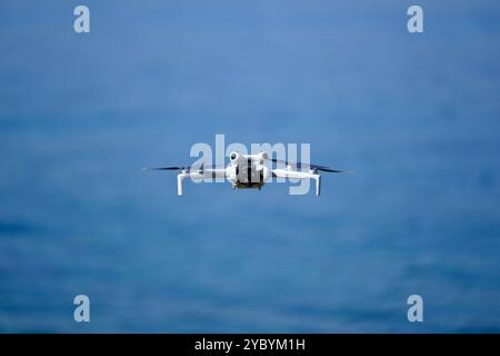 Mini drone flying over the sea in a sunny summer day, DJI mini pro 4 Stock Photo