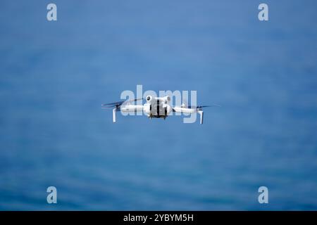 Mini drone flying over the sea in a sunny summer day, DJI mini pro 4 Stock Photo