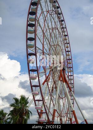 Ferris wheel from bottom to top. Attraction cabins against the gray sky. At the resort. Red and white Ferris wheel Stock Photo