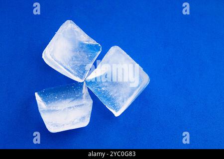 Three ice cubes on blue background Stock Photo