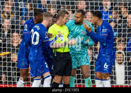 (241021) -- LIVERPOOL, Oct. 21, 2024 (Xinhua) -- Chelsea's goalkeeper Robert Sanchez (2nd R) and teammates protest to referee John Brooks after a second penalty was awarded to Liverpool, the referee later disallowed the penalty, during the English Premier League match between Liverpool and Chelsea in Liverpool, Britain, on Oct. 20, 2024. (Xinhua) FOR EDITORIAL USE ONLY. NOT FOR SALE FOR MARKETING OR ADVERTISING CAMPAIGNS. NO USE WITH UNAUTHORIZED AUDIO, VIDEO, DATA, FIXTURE LISTS, CLUB/LEAGUE LOGOS OR 'LIVE' SERVICES. ONLINE IN-MATCH USE LIMITED TO 45 IMAGES, NO VIDEO EMULATION. NO USE IN BETT Stock Photo