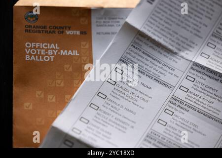 Fullerton, California, USA - October 20, 2024: Afternoon light shines on table of election materials and a blank vote by mail ballot for Donald Trump Stock Photo