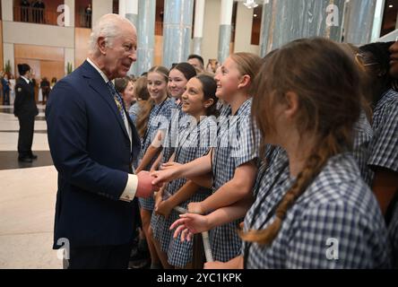 King Charles III speaks to school children at the Ceremonial Welcome to Australia at Australian Parliament House in Canberra, marking the King's first visit as sovereign to Australian Parliament House, on day two of the royal visit to Australia and Samoa. Picture date: Monday October 21, 2024. Stock Photo