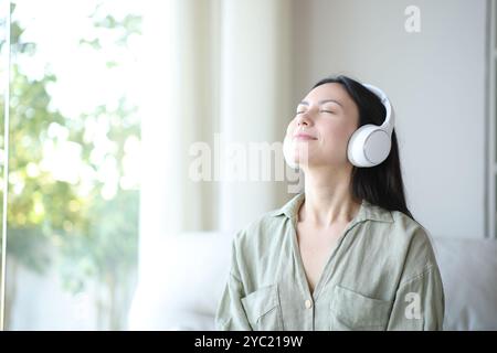 Asian woman breathing relaxing listening audio with headphone at home Stock Photo