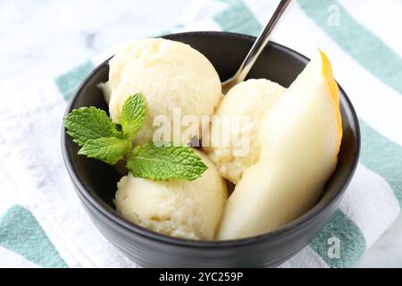 Scoops of tasty melon sorbet with mint and spoon in on white table, closeup Stock Photo