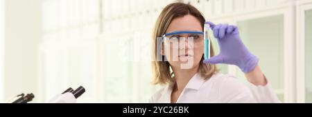 Scientist in goggles examines condition of blue reagent Stock Photo
