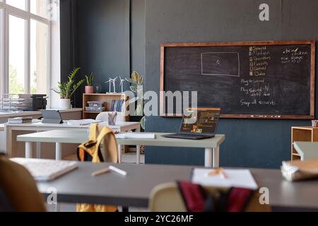 Background image of school classroom with programming lesson on blackboard and laptop on desk no people Stock Photo