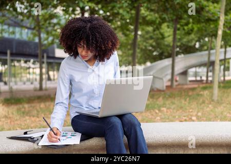 female entrepreneur working remotely in park Stock Photo