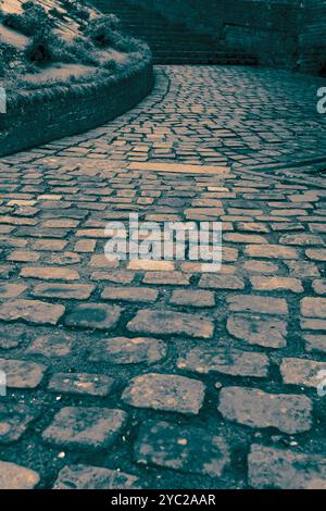 block paving path pavement sidewalk with steps and wall in an old English street. With colour toning Stock Photo