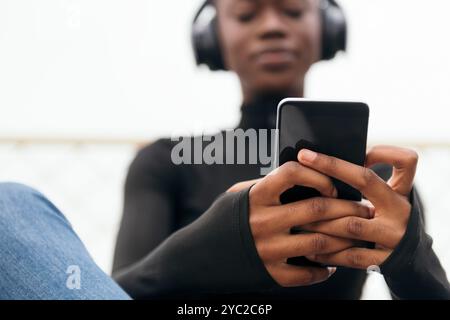 young female in headphones listening song on phone Stock Photo