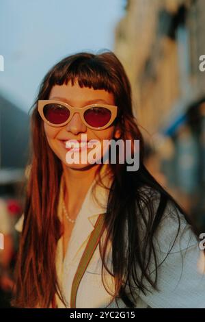 Happy smiling woman standing in city on sunny day. Stock Photo