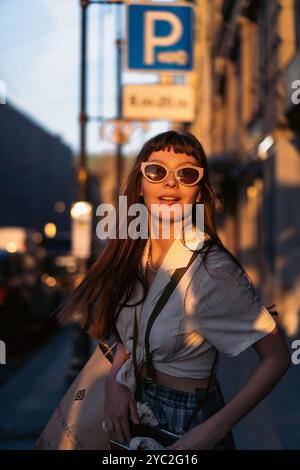 Happy smiling woman standing in city on sunny day. Stock Photo